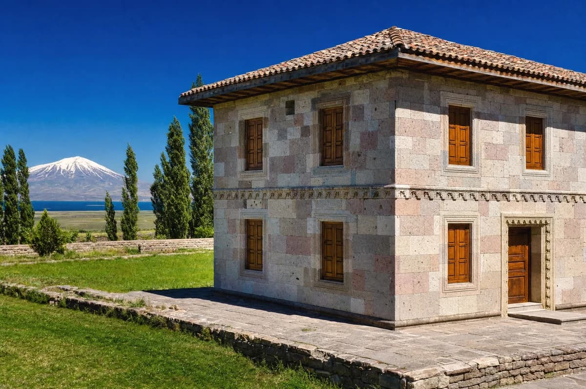 Van Gölü kıyısında, pembemsi köfke taşından sıvasız örülmüş iki katlı Ahlat evi ve arkasında Süphan Dağı